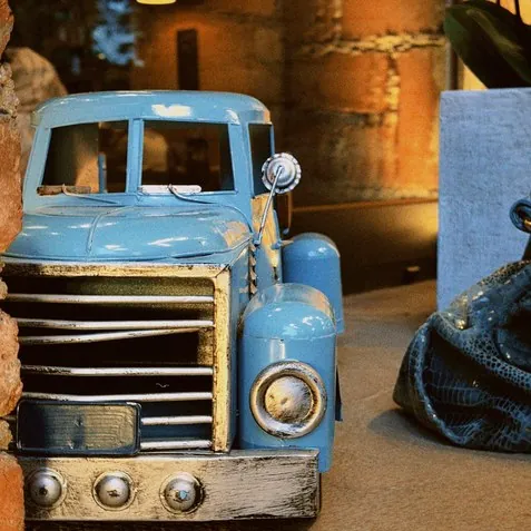 The front of the blue vintage truck inside the hall